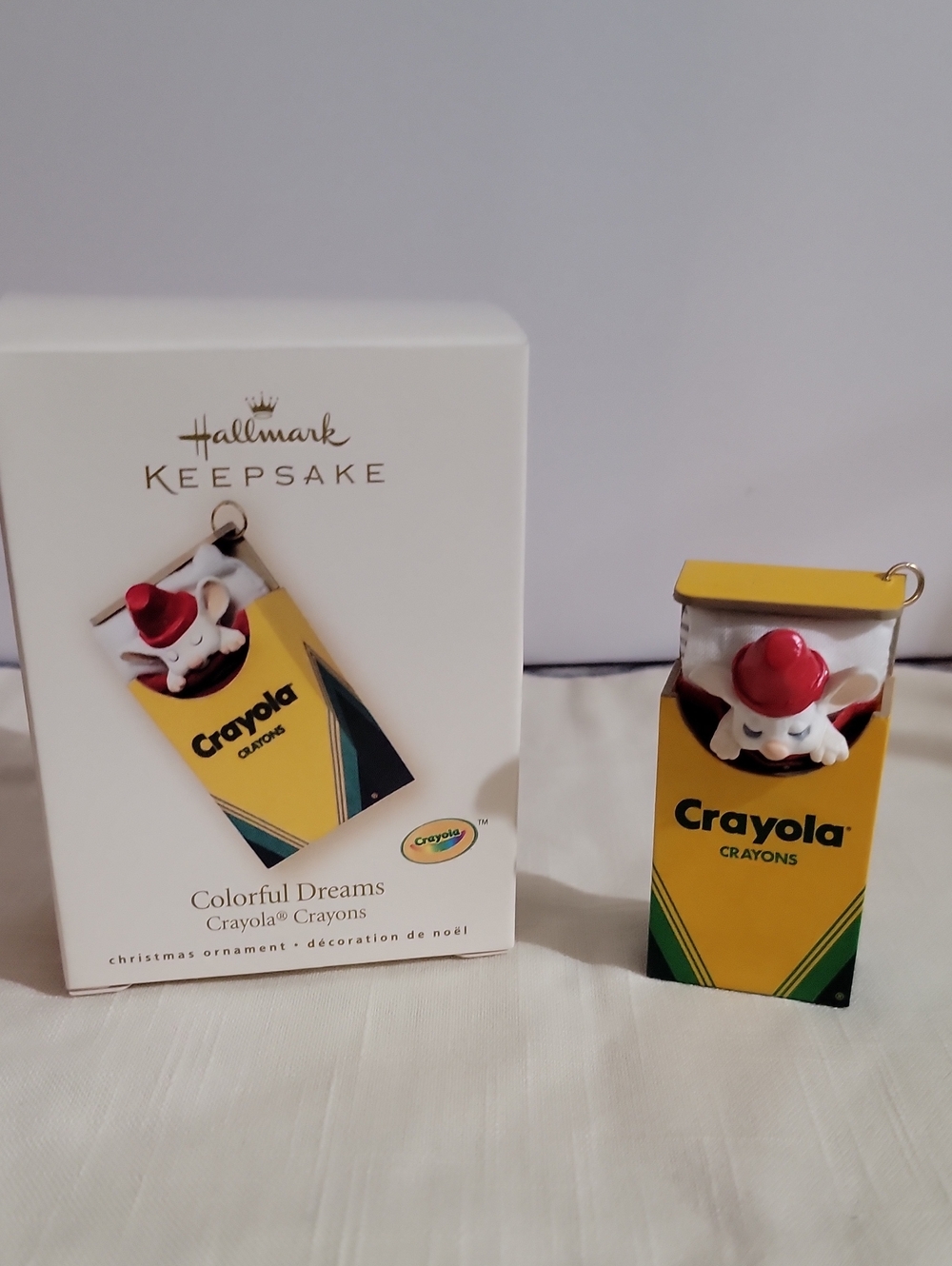 2007 Hallmark Crayola Yellow Crayon Box Ornament with Red-Hatted Character